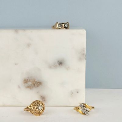 une boîte en marbre blanc contenant deux bagues et une bague posée dessus