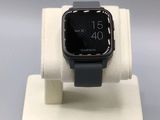 une Apple Watch noire posée sur un présentoir blanc