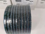 a close up of a stack of silver bracelets on a table