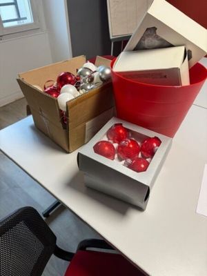 a table with a box of christmas ornaments and a box of ornaments on it