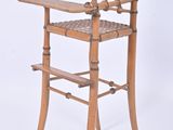 a wooden high chair with a woven seat on it