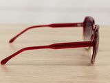 sunglasses on a wooden table with a white wall in the background