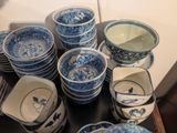 many blue and white plates and bowls on the table