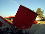 a red dumpster sitting on the back of a truck