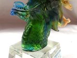 une sculpture en verre représentant un oiseau perché sur une branche d'arbre