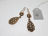 a pair of earrings with pearls on them and a price tag