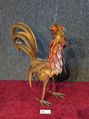 une sculpture représentant un coq, exposée sur un socle rouge