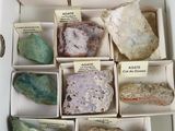 plusieurs boîtes contenant des cailloux de différentes couleurs, rangées dans une boîte munie d'étiquettes