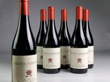 six bouteilles de vin rouge sont alignées sur une table
