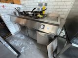 une cuisine équipée d'une cuisinière, d'un évier et d'autres appareils électroménagers