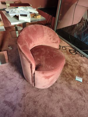 une chaise rose placée devant un miroir dans une pièce
