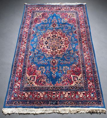 un tapis bleu et rouge orné d'un motif en médaillon