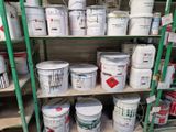 de nombreux seaux de peinture sur les étagères du magasin
