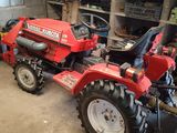 a red tractor that is parked in a garage