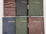 Quatre livres de couleurs différentes sont alignés sur une surface blanche