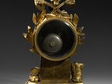 an image of a gold clock sitting on top of a table