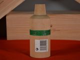 a bottle with a label on it sitting on a bed