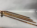 four wooden canes sitting on top of a white table