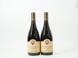 deux bouteilles de vin posées l'une à côté de l'autre sur une surface blanche
