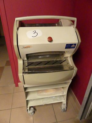 une machine posée par terre près d'un mur rouge