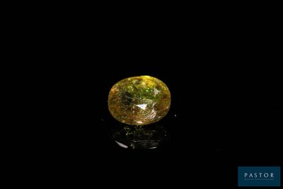 a close up of a yellow diamond on a black surface