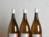 trois bouteilles de vin posées sur une table en bois