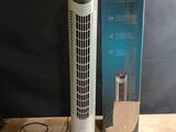 une boîte contenant un purificateur d'air posée sur une table à côté d'une boîte de câbles