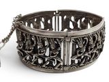 an antique silver bracelet with a chain on a white background