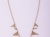 a gold necklace with a bird design on it