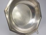 an antique silver plate on a stand on a white background