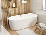 a white bath tub sitting in a bathroom next to a window