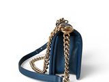 a blue purse with a gold chain hanging from it ' s shoulder