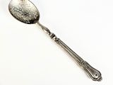 une cuillère posée sur une surface blanche