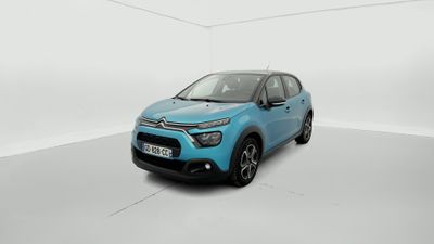 Une voiture bleue est garée dans une pièce blanche.