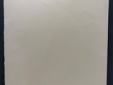 une feuille de papier blanche accrochée à un mur noir