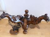 une statue de dragon posée sur une table, avec une paire de chaussures à côté