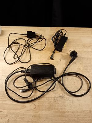 beaucoup de fils et de câbles sur la table, à côté d'un ordinateur portable
