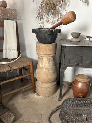 une pièce avec un poêle, une chaise, une table et une casserole