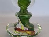 a small glass vase with a green leaf on it