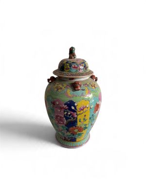 a colorful vase with a lid sitting on a white surface
