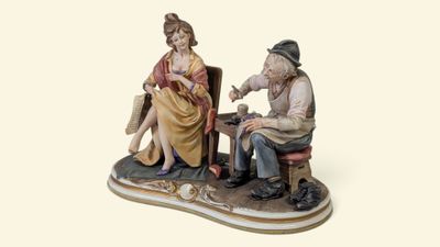 une figurine représentant un homme et une femme assis sur une chaise