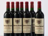 six bottles of red wine are lined up on a white surface
