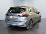 the rear end of a silver car in a showroom