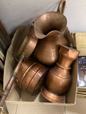 une boîte remplie de casseroles et de poêles en cuivre, ainsi qu'un livre