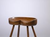 une photo d'un tabouret en bois posé sur un sol blanc
