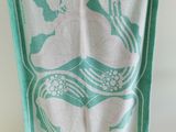 une serviette turquoise et blanche suspendue à un porte-vêtements dans une pièce