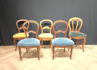 four chairs are lined up in a row on a wooden floor