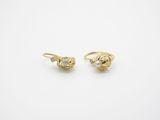 une paire de boucles d'oreilles en or jaune serties de diamants sur fond blanc