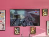 a pink wall with pictures on it in a restaurant