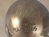 a bronze sculpture of a man ' s head on top of a plaque